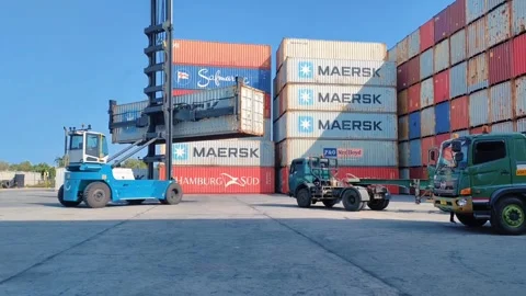 Two trucks positioned in front of a towering stack Stock Footage 312021702