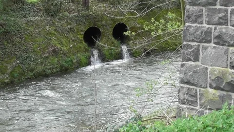 Two tubes ending in a small river 스톡 동영상 270540154