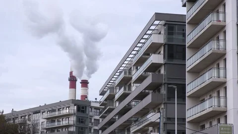 Two tubes of the heating station release white steam among modern city buildings Stock Footage 124355987