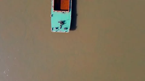 Two tug boats pushing large and long rusty, green-orange barge Stock Footage 151249085