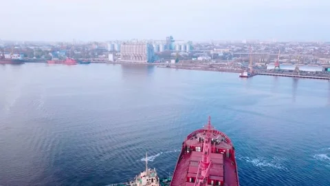 Two tugs are doing work on mooring a large cargo ship for loading grain at the s 스톡 동영상 139280316