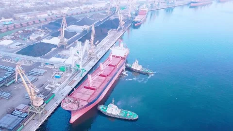 Two tugs are doing work on mooring a large cargo ship for loading grain at the s 스톡 동영상 139280606