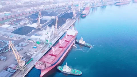 Two tugs are doing work on mooring a large cargo ship for loading grain at the s 스톡 동영상 139280926