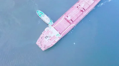 Two tugs are doing work on mooring a large cargo ship for loading grain at the s 스톡 동영상 139281201