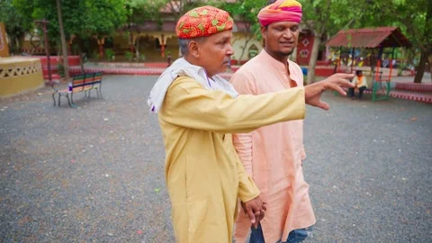 Two turbaned men walk as chat in ethnic wear outdoor Stock Footage 304848331