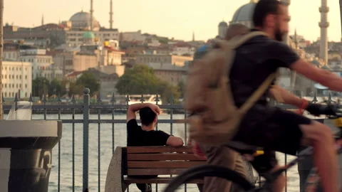Two Turkish men sit on a bench watching the Golden Horn Stock Footage 154574690