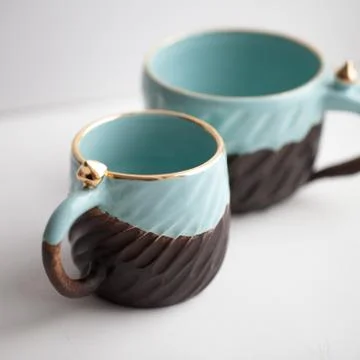 Two turquoise cups for tea or coffee on the white table Stock Photos