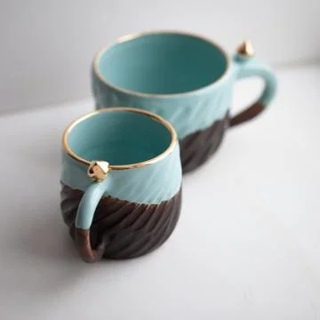 Two turquoise cups for tea or coffee on the white table Stock Photos