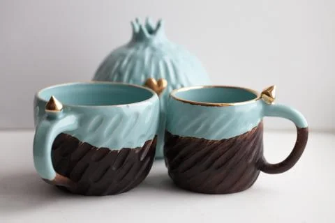 Two turquoise cups for tea or coffee on the white table Stock Photos