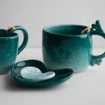 Two turquoise cups for tea or coffee on the white table Stock Photos