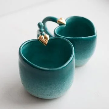 Two turquoise cups for tea or coffee on the white table Stock Photos
