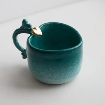 Two turquoise cups for tea or coffee on the white table Stock Photos