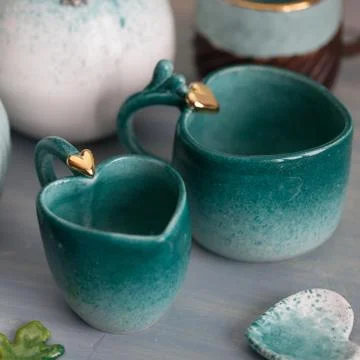 Two turquoise cups for tea or coffee on the white table Stock Photos