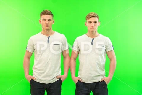 The two twin brother stand on the green background Stock Photos