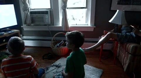 Two Twin Brothers sit in front of a television playing video games and then wres Stock Footage 55337334