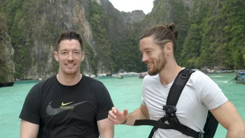Two twin brothers smiling at the camera, happy to be on vacation together in Vidéo 303978958