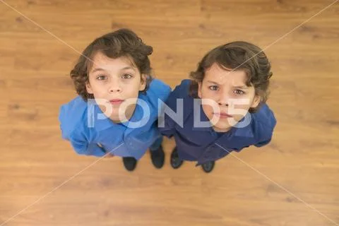 The two twin kids look to the camera. View from above Stock Photos