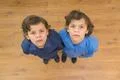 The two twin kids look to the camera. View from above Photo