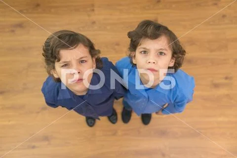 The two twin kids look to the camera. View from above Stock Photos