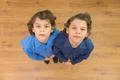 The two twin kids look to the camera. View from above Photo