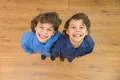 The two twin kids smile to the camera. View from above Photo
