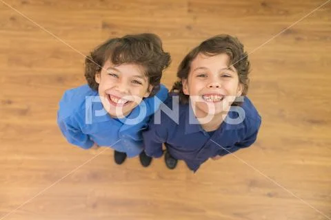 The two twin kids smile to the camera. View from above Stock Photos