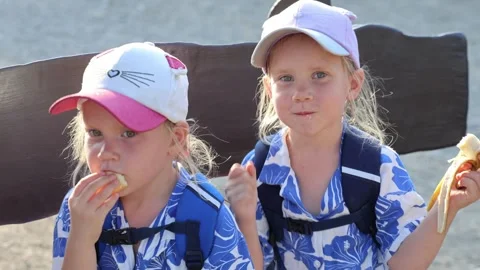 Two twin sisters dancing sitting on a bench 库存影片 313562693