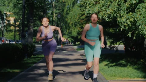 Two twin sisters starting to run in a park during a sunny day Vídeos de archivo 336965566