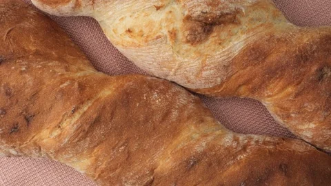 Two twisted baguettes rotating on a surface Stock Footage 344908825
