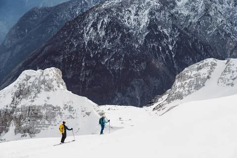 Two two tourers going down the snowy mountain, view of the mountains in the Stock Photos