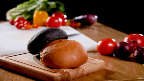 Two types of buns for а burger on a table with lots of vegetables. Stock Footage 94034730