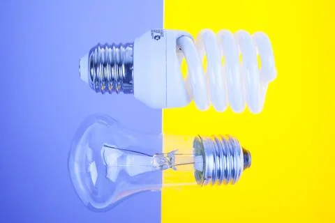 Two types of light bulbs on yellow and blue background Stock Photos