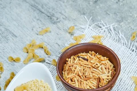 Two types of uncooked pasta on a gray background Stock Photos
