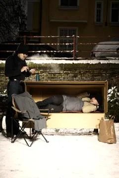 Two ugly men sharing paper box in winter city park Stock Photos