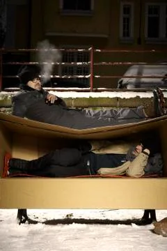 Two ugly men sharing paper box in winter city park Stock Photos