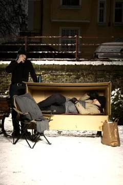Two ugly men sharing paper box in winter city park Stock Photos