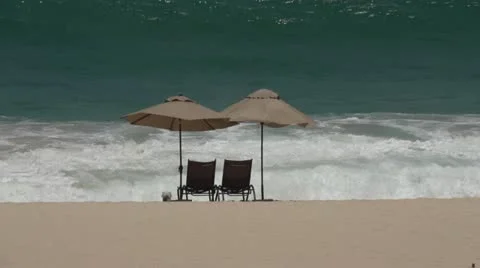 Two Umbrellas on the beach in front of waves Video stock 11681199