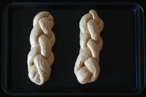 Two uncooked challah sweet bread on a baking tray Stock Photos