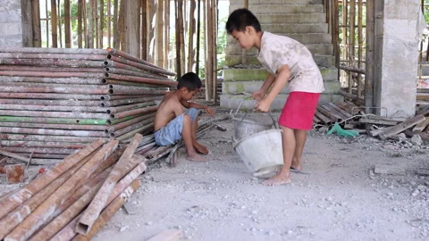Two underage workers performing manual labor in an indoor construction site Stock Footage 336950987