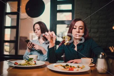Two unhappy lesbians not talking to each other after having quarrel during lunch Stock Photos
