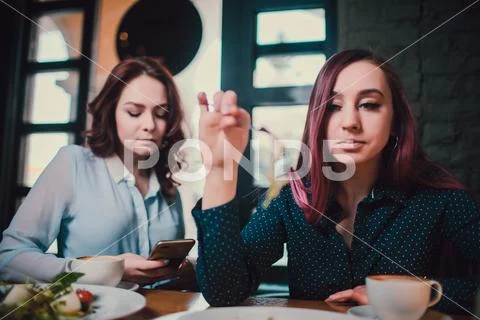 Two unhappy lesbians not talking to each other after having quarrel during lunch Stock Photos