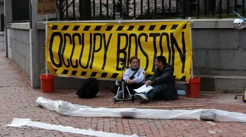 Two unidentified protesters sit at an Occupy Wall Street demonstration outside o Stock Footage 12113285