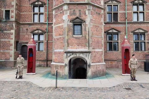 Two uniformed guards stand on duty in front of the historic brick building .. Stock Photos