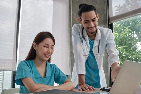 Two uniformed young doctors work in medical clinic office. Fotos de archivo