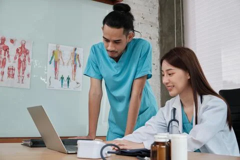 Two uniformed young doctors work in medical clinic office. Fotos de archivo
