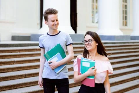 Two university students going home talking after their class Stock Photos