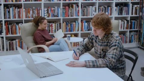 Two university students studying in a campus library 库存影片 335127570