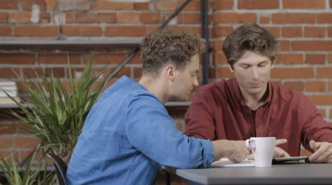 Two university students working on project together in loft modern interior 動画素材 67672195