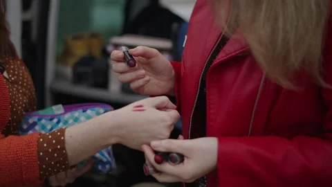 Two unrecognizable friends try on lipstick Video stock 280275598