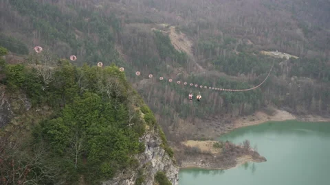 Two unrecognizable people launching on a zip line over the Bubal reservoir Stock Footage 191859757